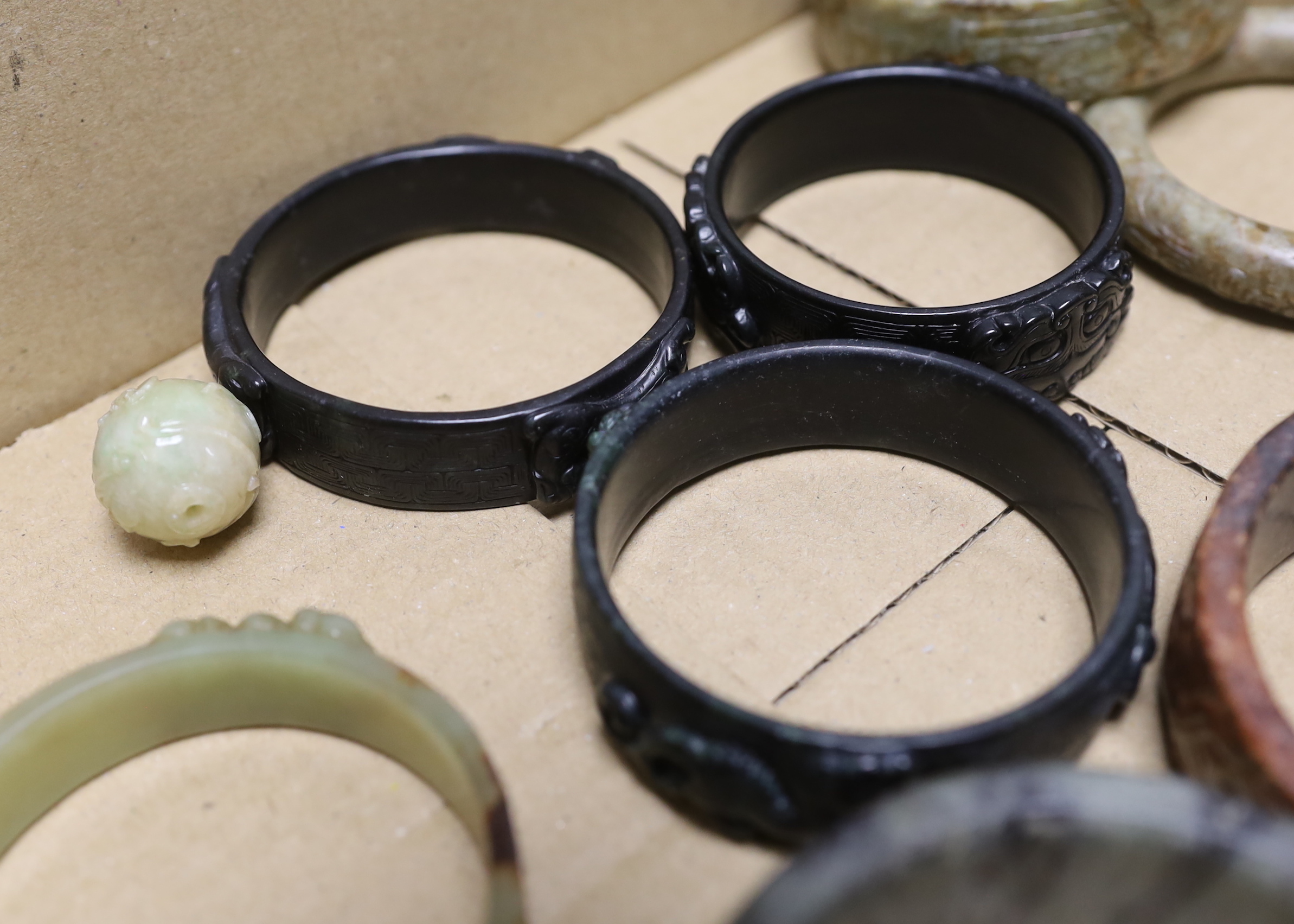 Nine assorted Chinese jade and hardstone bangles and three spheres, largest bangle 8.5cm diameter